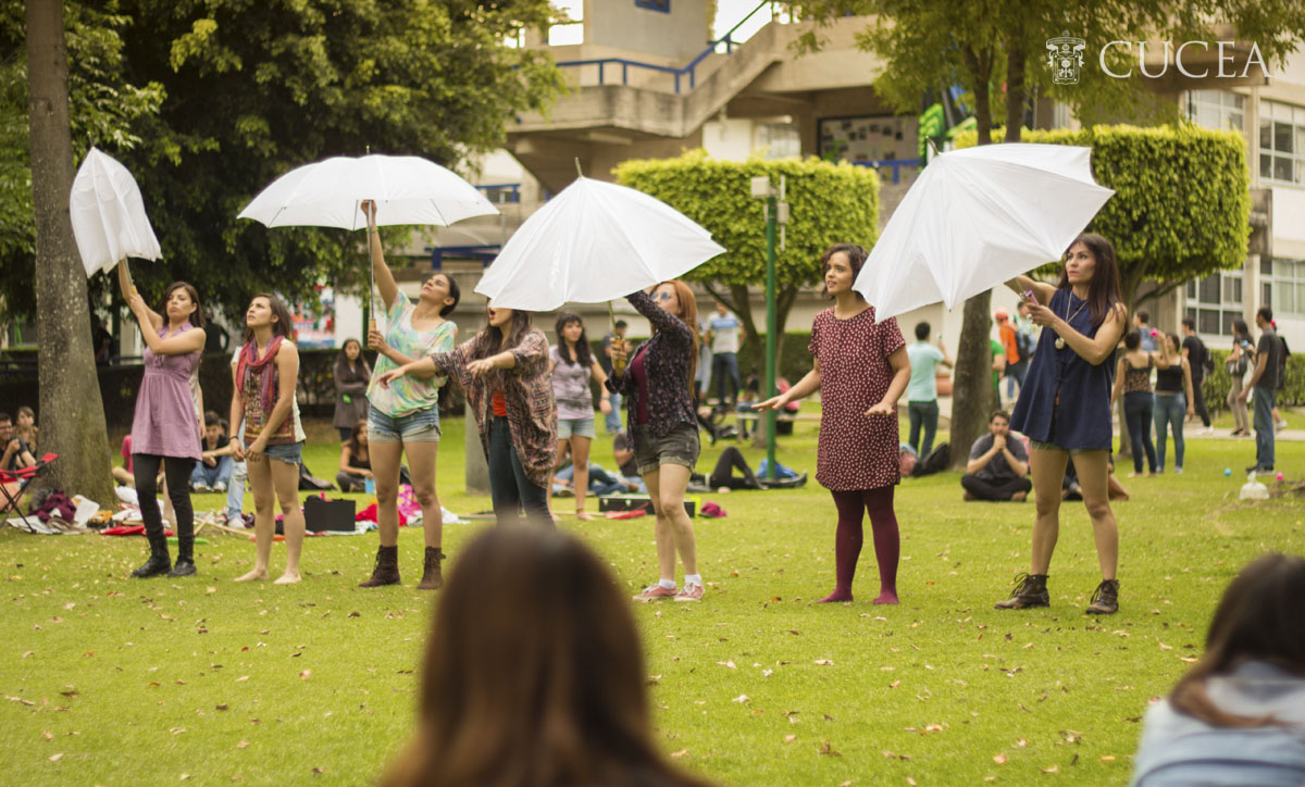 Estudiantes abriendo sombrillas blancas en ciber jardín